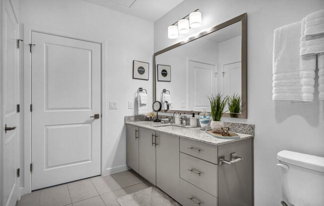 a bathroom with a large mirror and a toilet and a sink