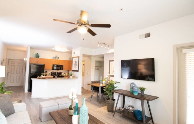 a living room and kitchen with a ceiling fan