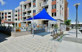 a blue tent is set up in front of Main Street Lofts Cupertino