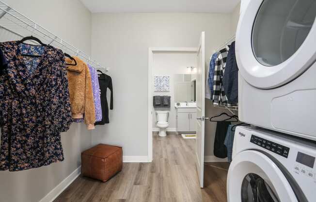 a laundry room with a washer and dryer and a door to a bathroom