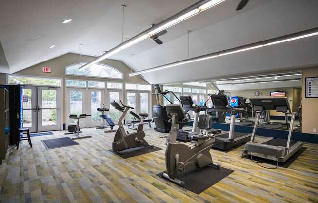 A gym with treadmills, elliptical machines, and other exercise equipment.