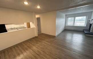 an empty living room with a kitchen and a window at Kings Court, Anchorage, AK ? 