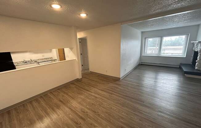 an empty living room with a kitchen and a window at Kings Court, Anchorage, AK ? 