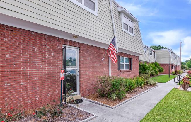 a brick building with grass in front of a house