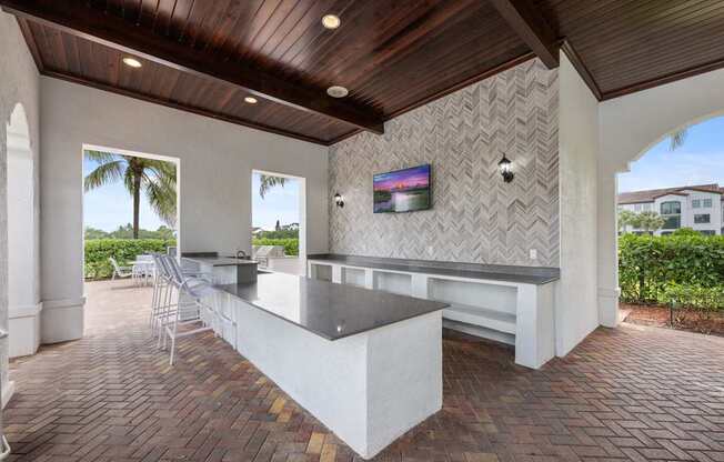 the pool bar is outfitted with a granite counter and a view of the house