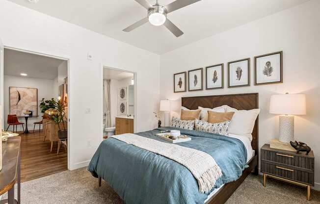 A bedroom with a bed, nightstand, and a ceiling fan.