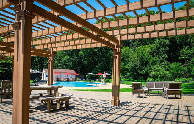 a patio with a pergola and a swimming pool