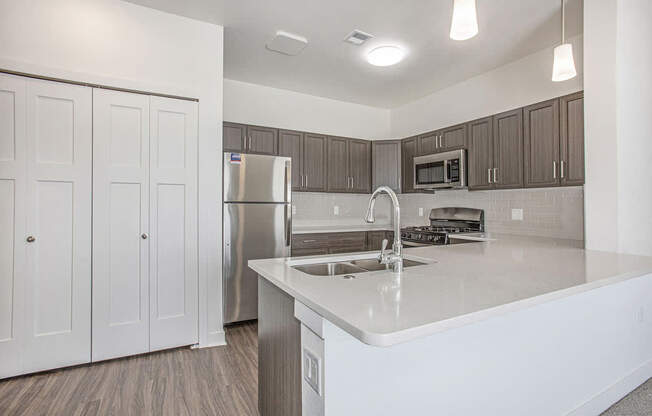 A kitchen with a breakfast bar at Meadowbrooke Apartment Homes in Kentwood, MI 49512