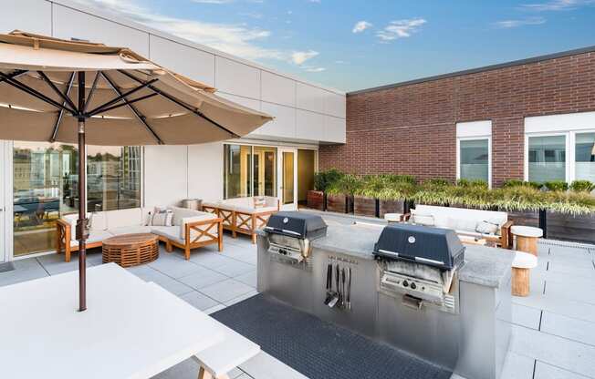 A patio with a grill and seating area.