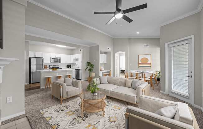 a living room with couches and chairs and a ceiling fan