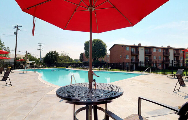 Large red umbrella with table near side of the pool at Rose Hill Apartments, Alexandria, VA, 22310