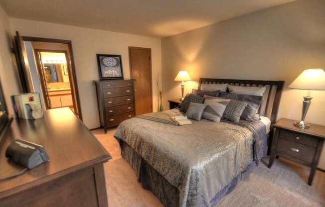 a bedroom with a bed and a dresser and a mirror