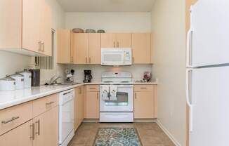 A kitchen with white appliances and wooden cabinets.