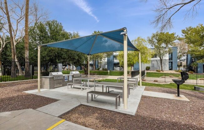 a picnic area with benches and a grill at the preserve at great pond apartments in windsor