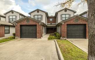 the front of a house with two black garage doors