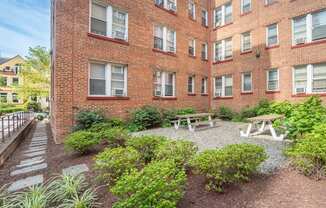 the courtyard of a brick building with a picnic table and benches