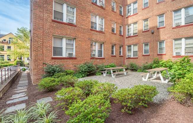 the courtyard of a brick building with a picnic table and benches