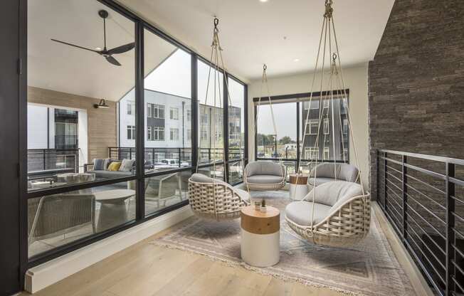 a living room with two hanging chairs and a large window