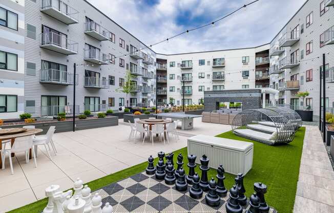 an apartment patio with tables and chairs and a large chess set