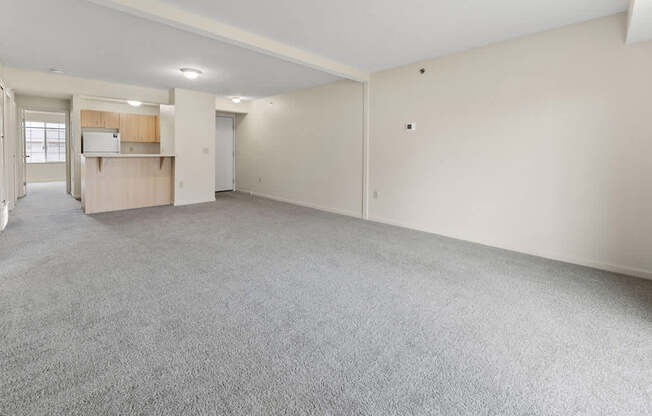 A large, empty dining room with a grey carpet at Fieldstream Apartment Homes in IA 50023