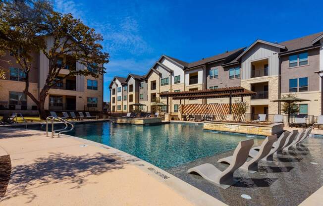 outdoor pool with lounge chairs at ironridge apartments