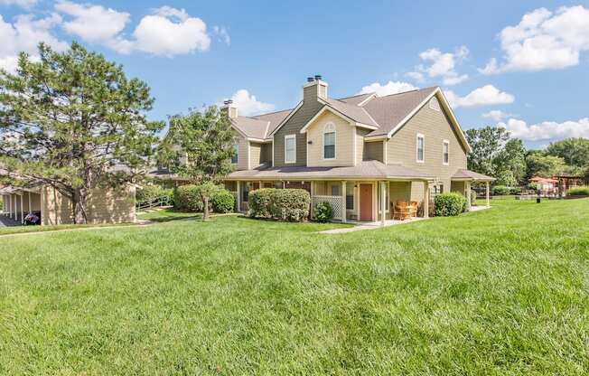 a large house on a hill with a grassy yard at Highland Ridge Apartments, Overland Park 