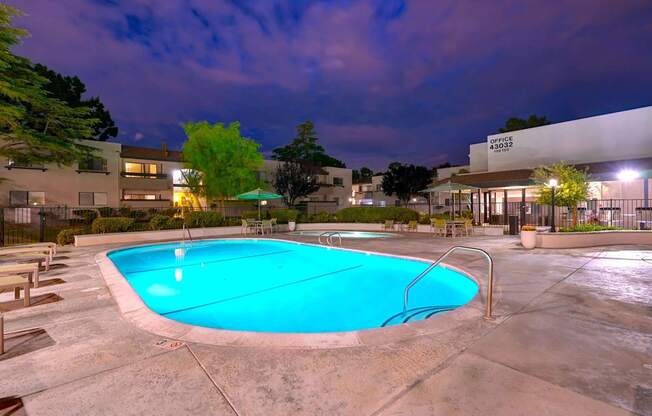 A swimming pool at a resort with a building in the background.