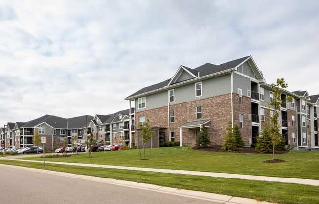 a large apartment complex with a street in the foreground and a parking lot in the background