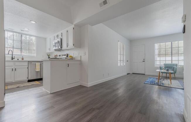 an empty living room and kitchen with wood floors  at The Resort at Encinitas Luxury Apartment Homes, Encinitas, California