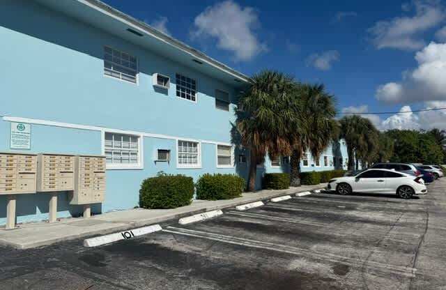 A blue building with a white car parked in front.