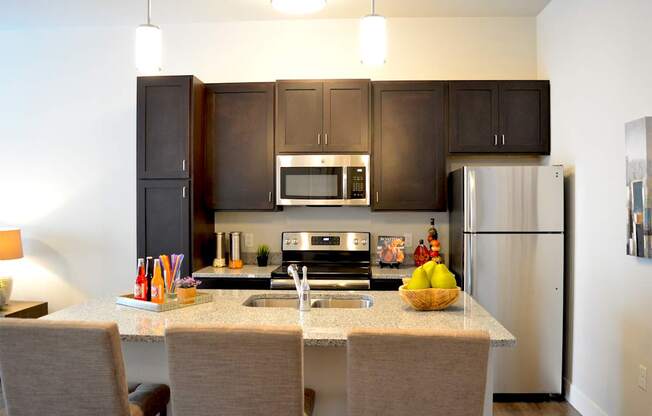 A kitchen with a table and chairs in front of it.