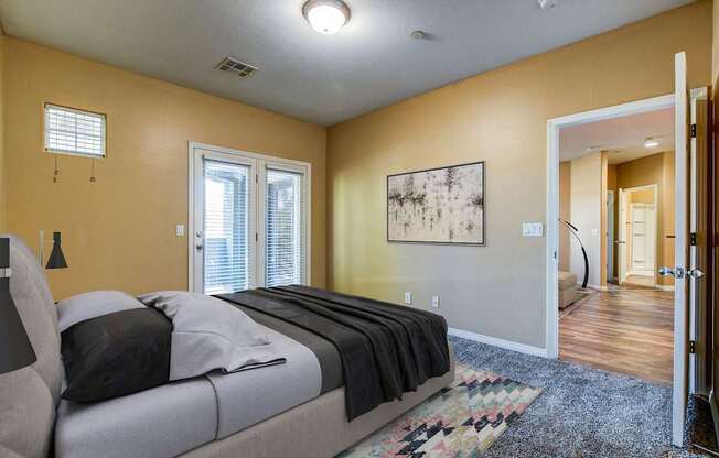 A bedroom with a bed, a rug, and a painting on the wall.