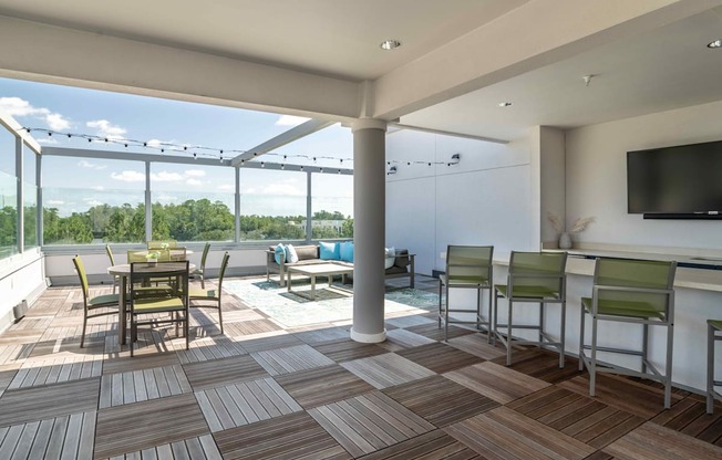 a patio area with a dining table and chairs and a flat screen tv