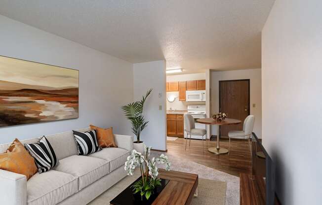 a living room and dining room with a couch and a table. Fargo, ND Parkwood East and West Apartments