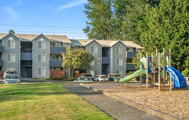 a playground in front of an apartment building with a slide