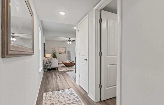 the entrance to a renovated house with white doors and a hallway with a living room