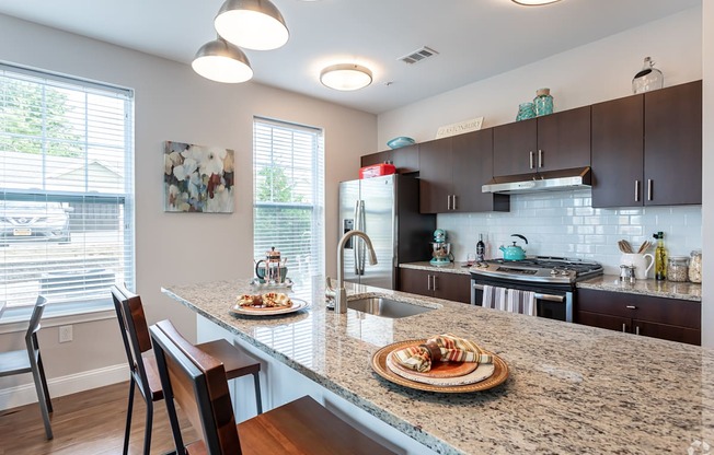 A kitchen with a table and chairs with food on it.