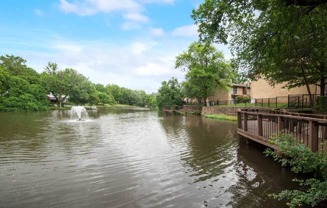 a view of a pond with a fountain in it and a building on the water