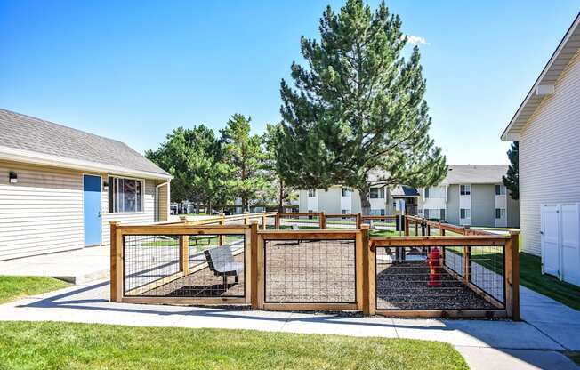 Kirkwood Meadows dog run with fence and a fire hydrant surrounded by green grass and trees in Pocatello, ID