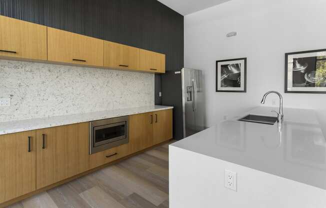 a kitchen with wooden cabinets and a white counter top and a sink