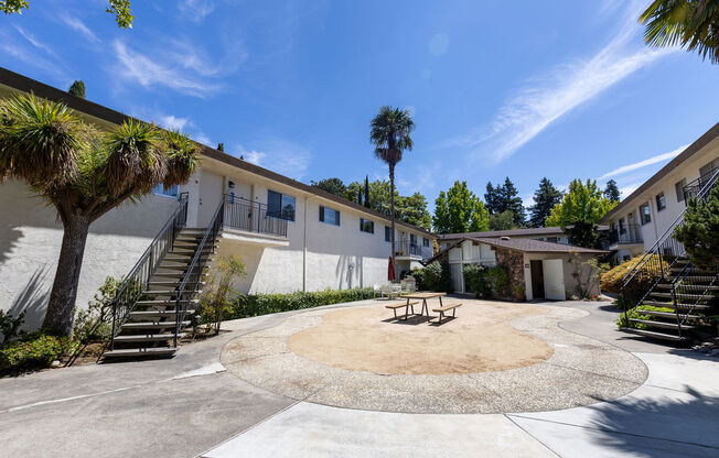 a courtyard with a picnic table in front of a building