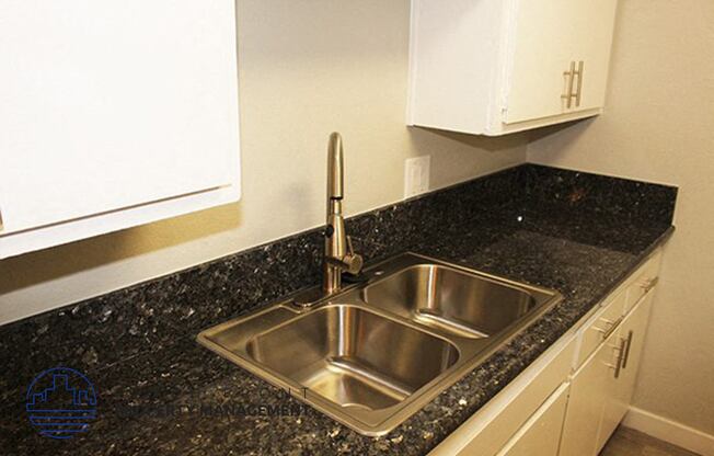 a kitchen with a sink and a granite counter top