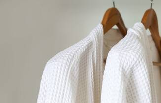 a rack of white linen dries on a wooden hanger