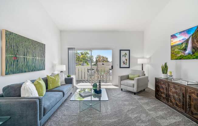 a living room with a blue couch and a glass coffee table