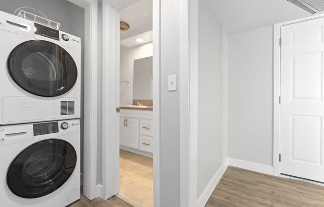 a white washer and dryer in a laundry room with a white door