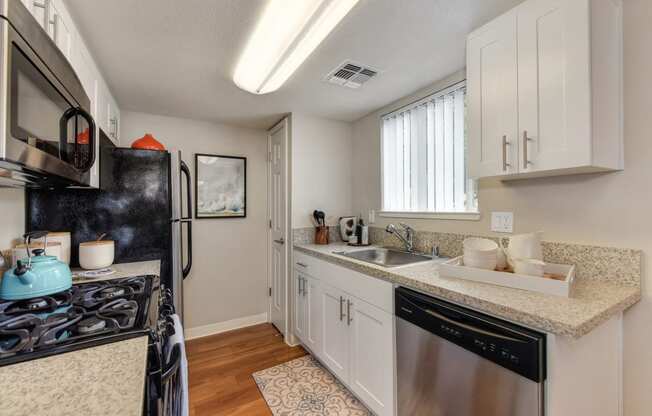 Dining Room/Kitchen with Wood Inspired Floor, Rug, Oven, Stove with Blue Tea Kettle, Microwave