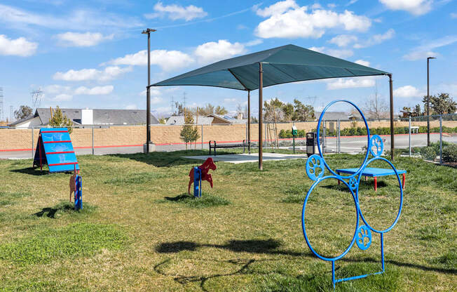 A playground with a blue swing set and a red slide.
