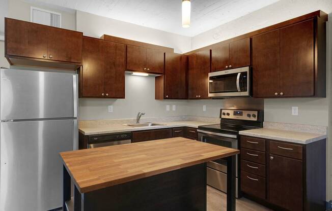 A kitchen with brown cabinets and a wooden island.