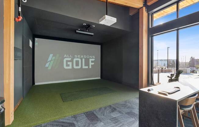 A room with a green carpet and a screen displaying "All Seasons GOLF".