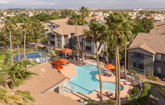 an aerial view of a swimming pool with palm trees